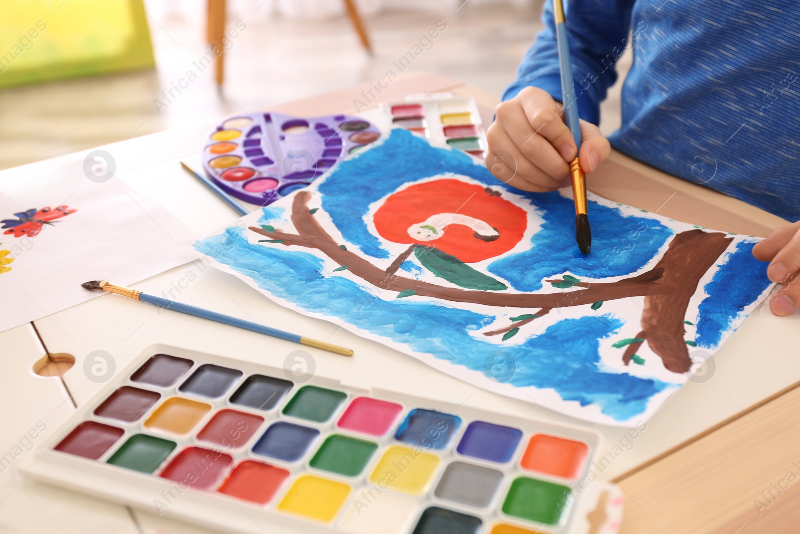 Photo of Little child painting at table, closeup view