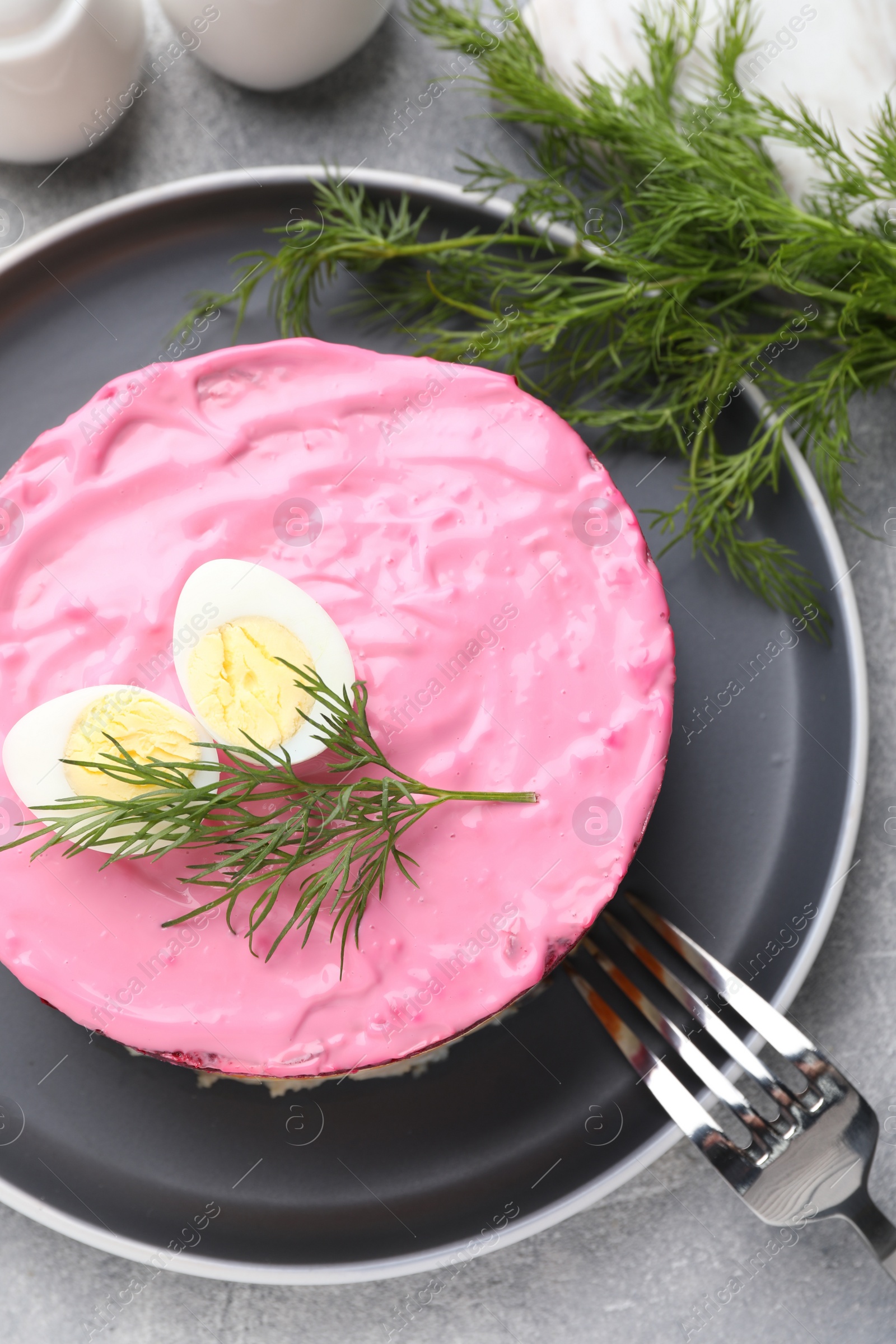 Photo of Herring under fur coat salad served on light grey table, flat lay. Traditional Russian dish