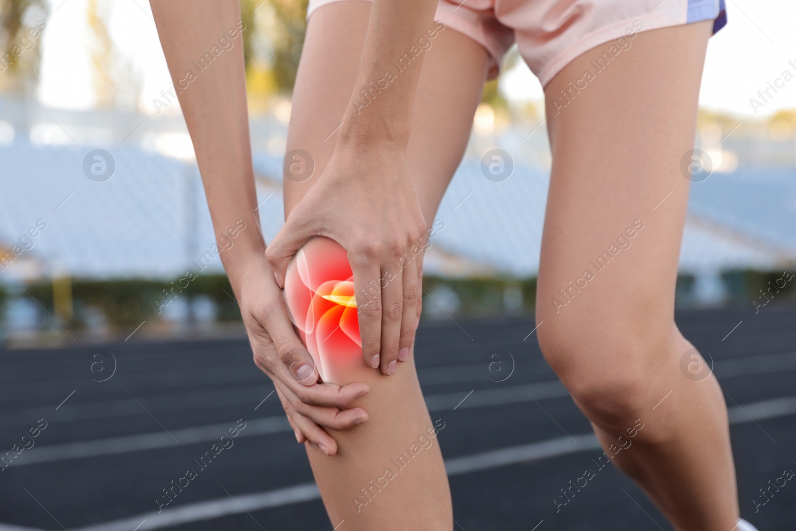 Image of Role of calcium for human. Woman suffering from pain in knee at stadium