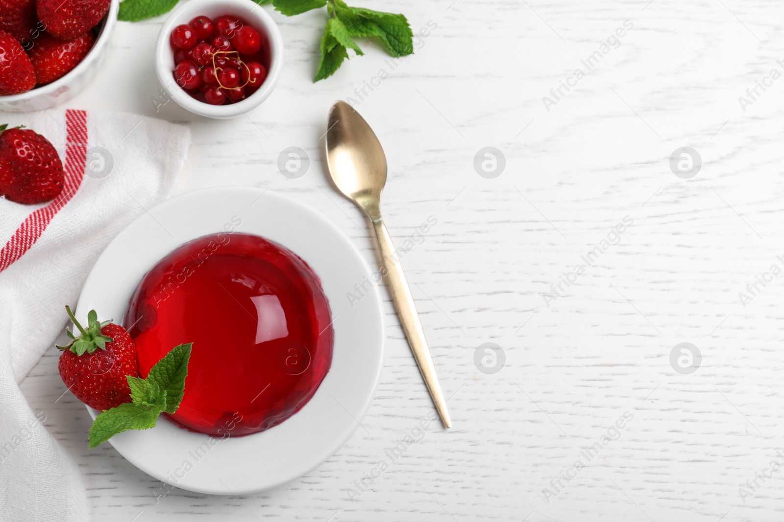 Photo of Delicious fresh red jelly with berries and mint on white wooden table, flat lay. Space for text