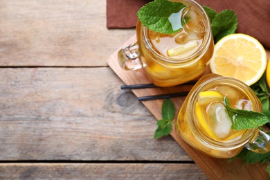 Photo of Delicious iced tea on wooden table, flat lay. Space for text