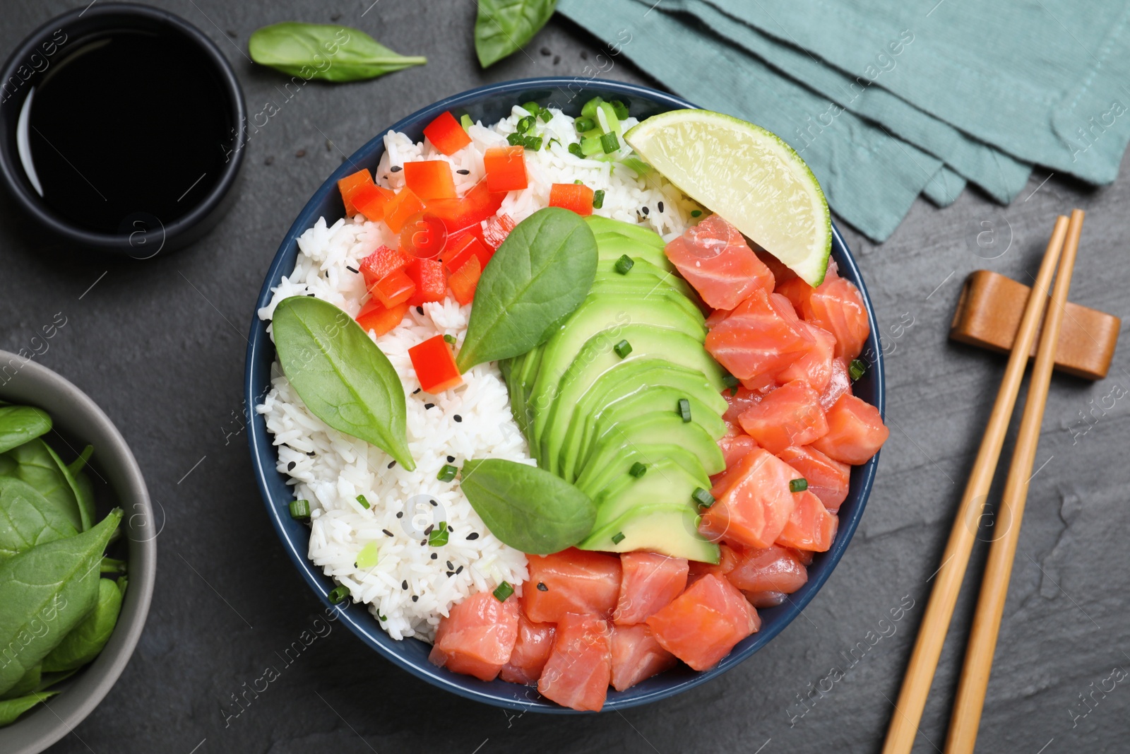 Photo of Delicious poke bowl with salmon, spinach and avocado served on black table, flat lay