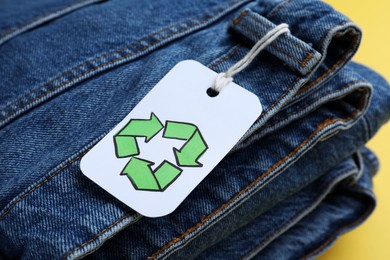 Folded jeans with recycling label, closeup view