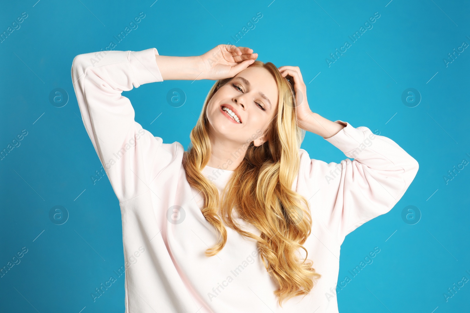 Photo of Portrait of beautiful young woman with dyed long hair on blue background