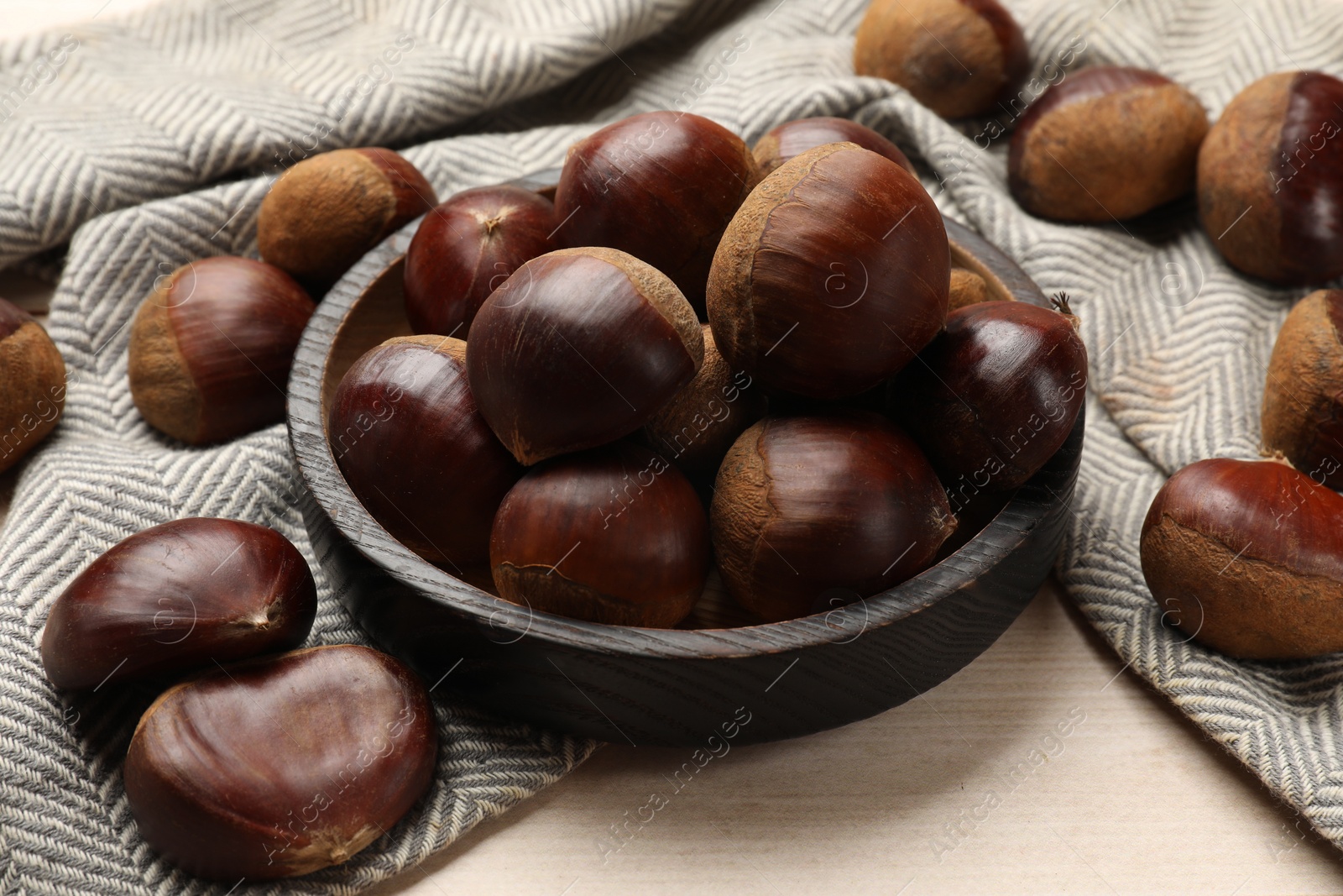 Photo of Sweet fresh edible chestnuts on light wooden table