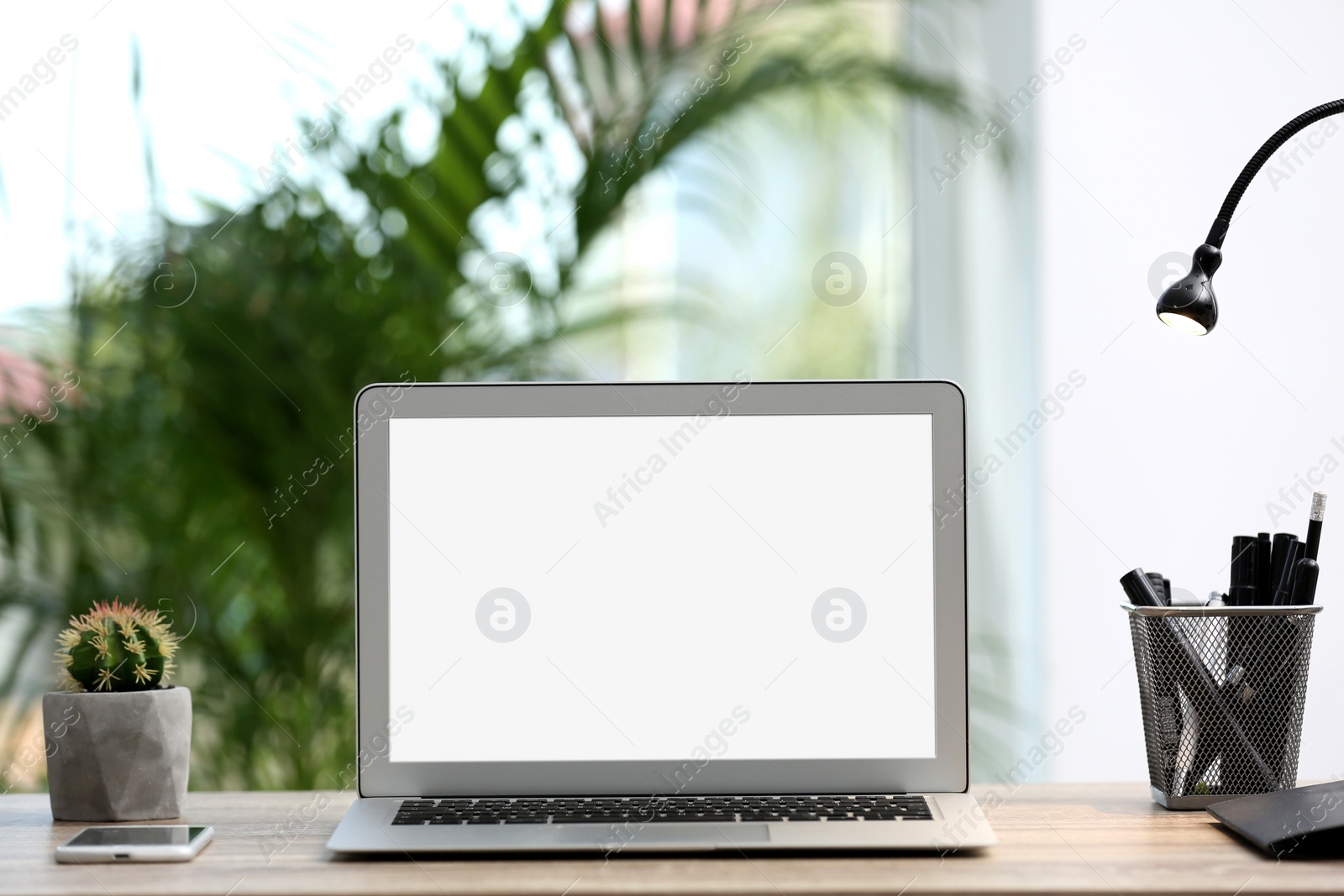 Photo of Modern laptop on desk in room. Home workplace