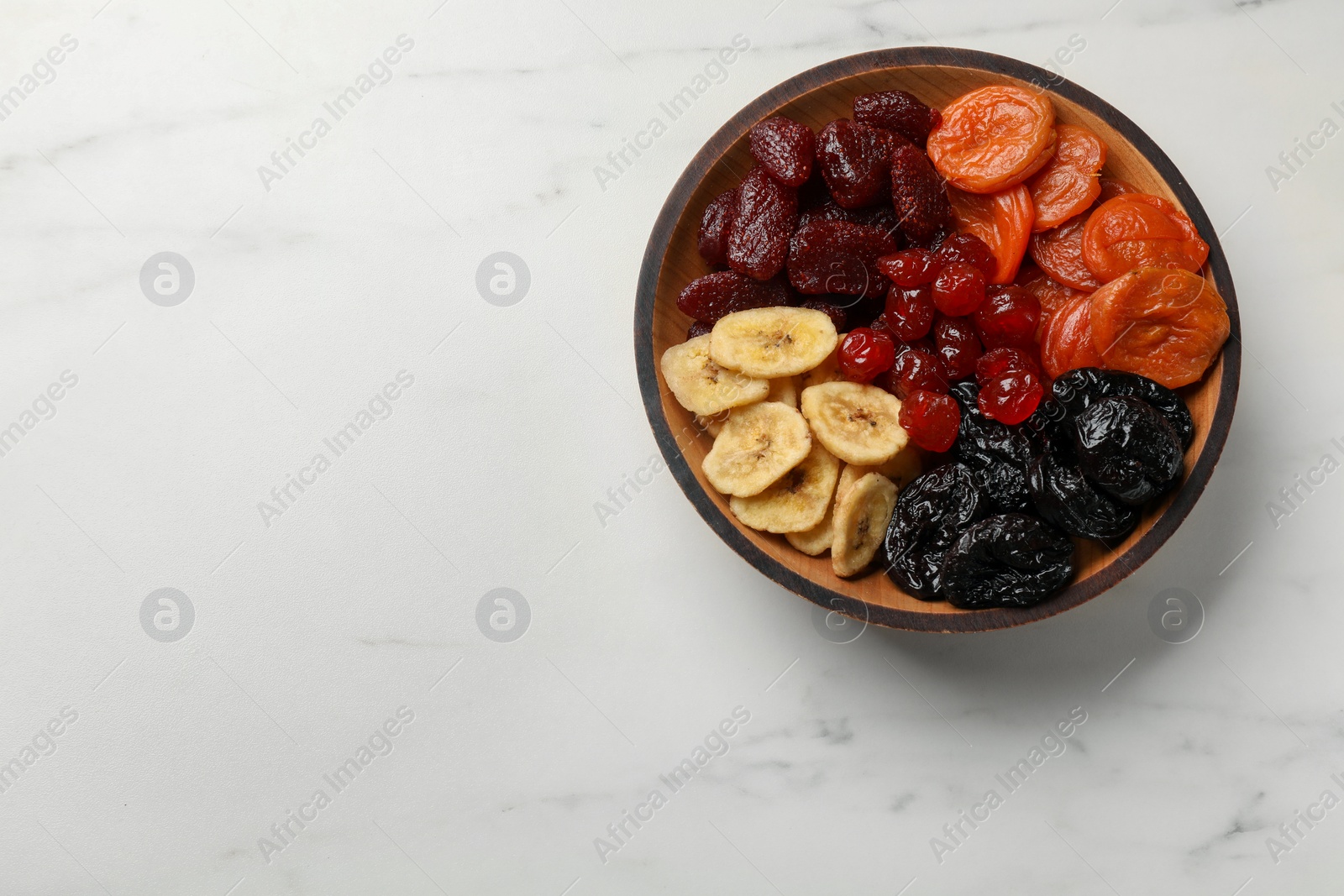 Photo of Mix of delicious dried fruits on white marble table, top view