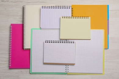 Photo of Many different notebooks on white wooden table, flat lay