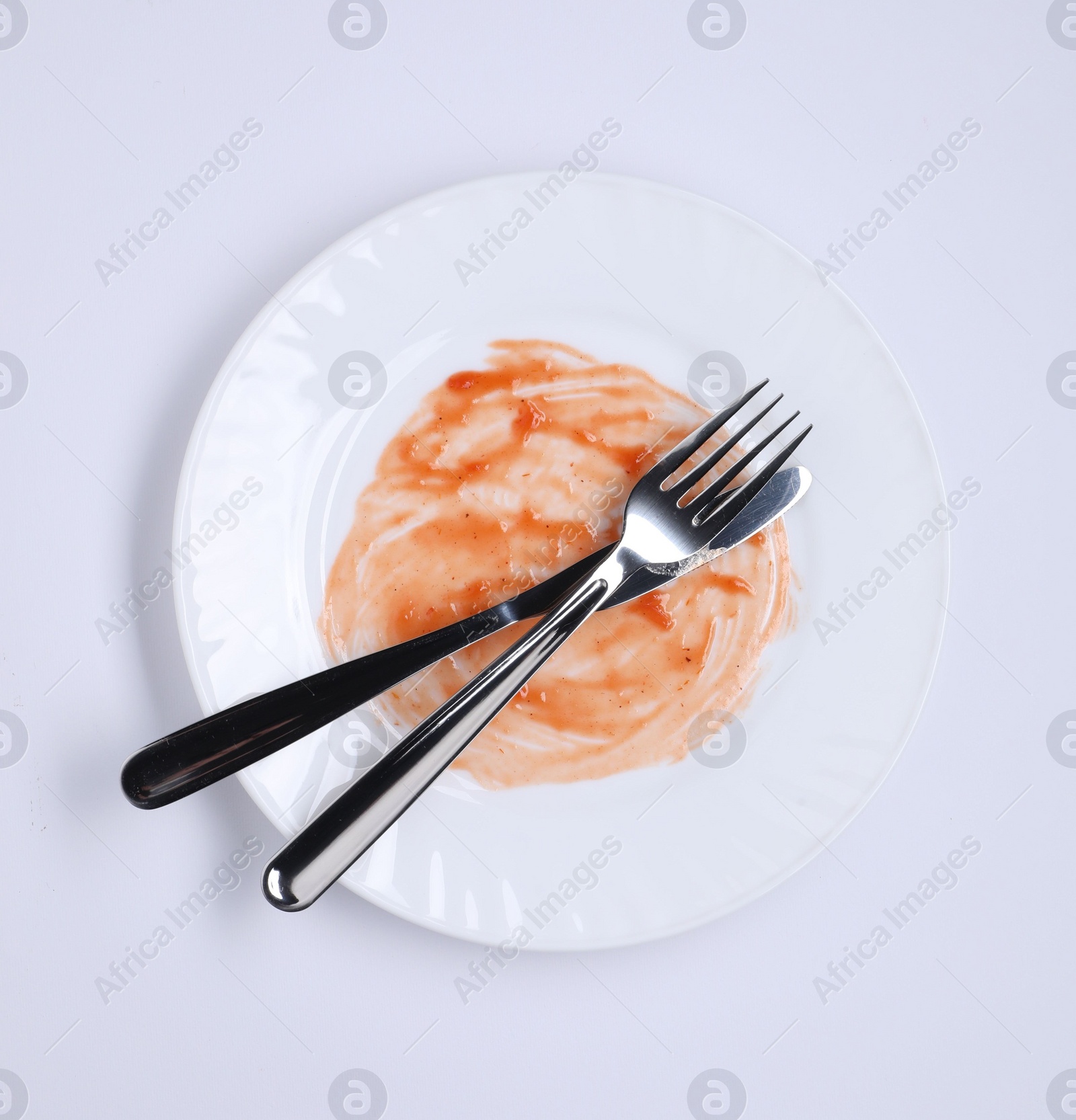 Photo of Dirty plate and cutlery on white background, top view