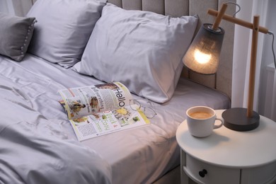 Photo of Magazine on bed with soft silky bedclothes in room