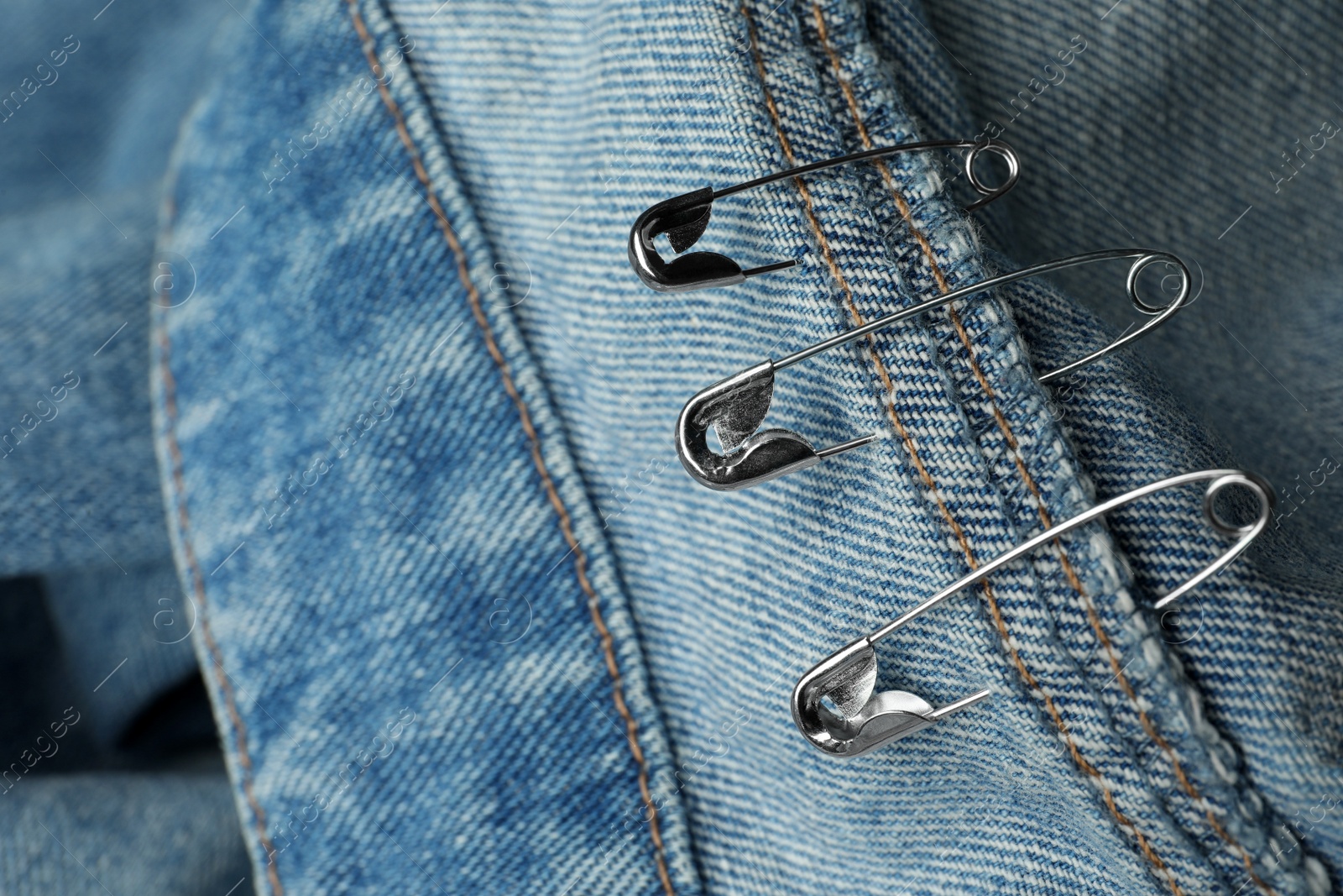 Photo of Closeup view of metal safety pins on clothing