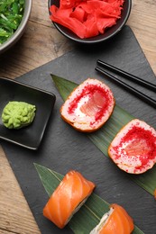 Flat lay composition with delicious sushi rolls on wooden table