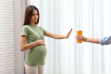 Photo of Pregnant woman refusing alcohol drink indoors. Bad habits during pregnancy