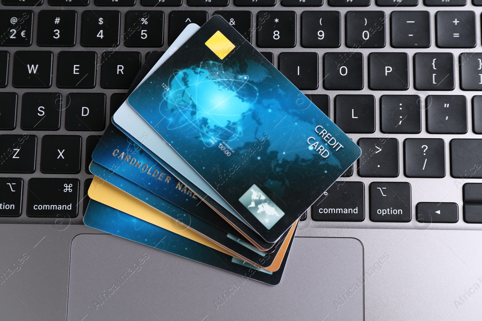 Photo of Many credit cards on laptop, flat lay