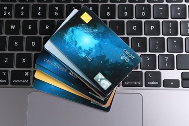 Photo of Many credit cards on laptop, flat lay