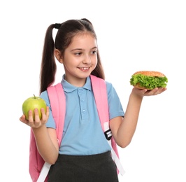 Happy girl with burger and apple on white background. Healthy food for school lunch