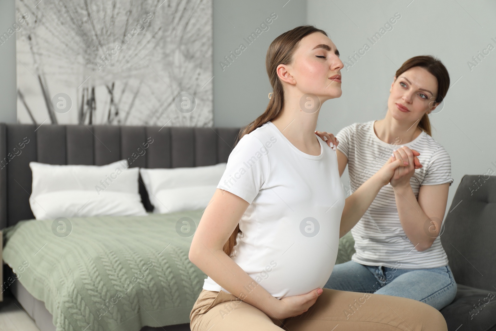 Photo of Doula working with pregnant woman in bedroom, space for text. Preparation for child birth