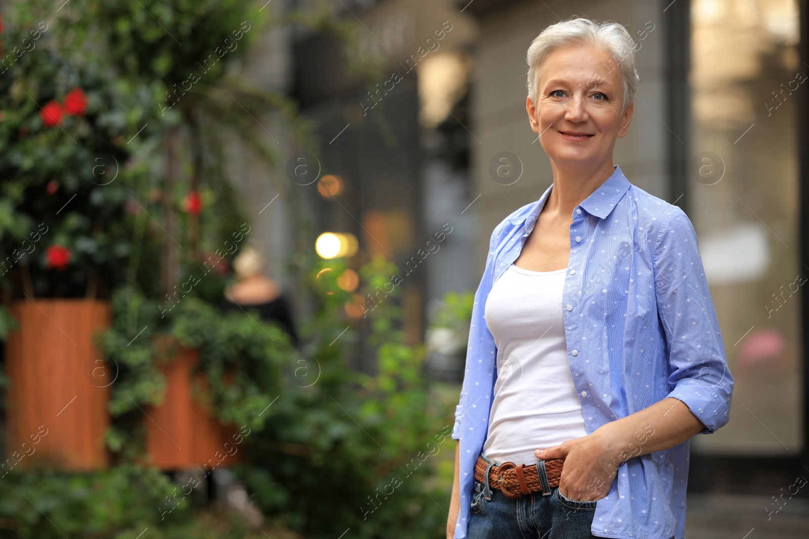 Photo of Happy mature woman on city street, space for text. Smart aging