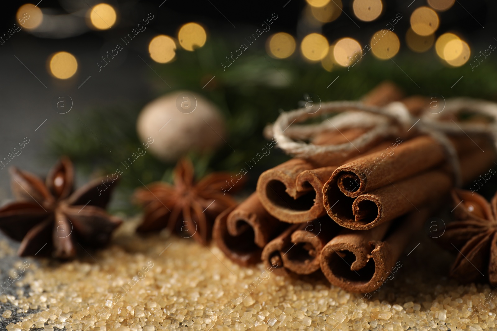 Photo of Different spices on table against blurred lights, closeup
