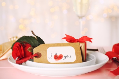 Elegant place setting for romantic dinner on pink table, closeup. Valentine's day celebration