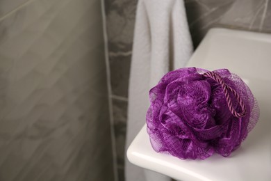 Photo of Purple shower puff on sink in bathroom, space for text