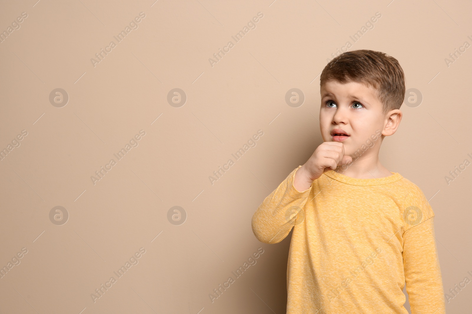 Photo of Cute boy suffering from cough on color background. Space for text