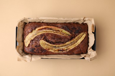 Delicious banana bread on beige background, top view