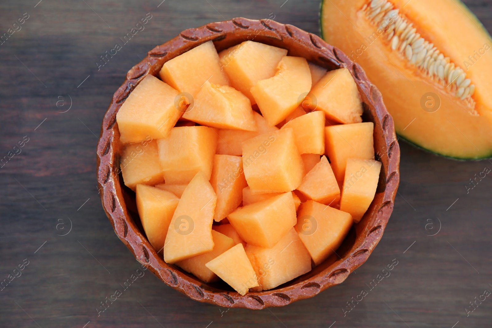 Photo of Cut delicious ripe melon on wooden table, flat lay