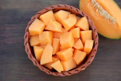 Photo of Cut delicious ripe melon on wooden table, flat lay