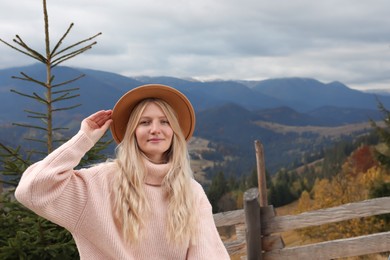 Photo of Portrait of beautiful young woman in mountains on autumn day, space for text