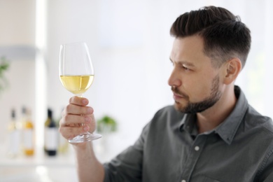 Photo of Young man with glass of wine indoors