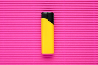 Photo of Stylish small pocket lighter on pink corrugated fiberboard, top view