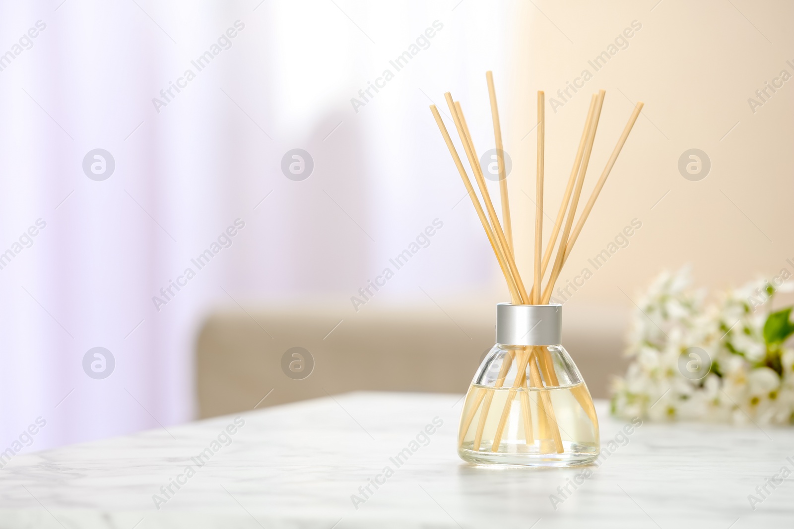 Photo of Aromatic reed freshener on table in room