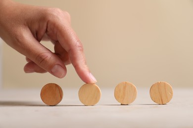 Choice concept. Woman choosing wooden circle among others at light table, closeup