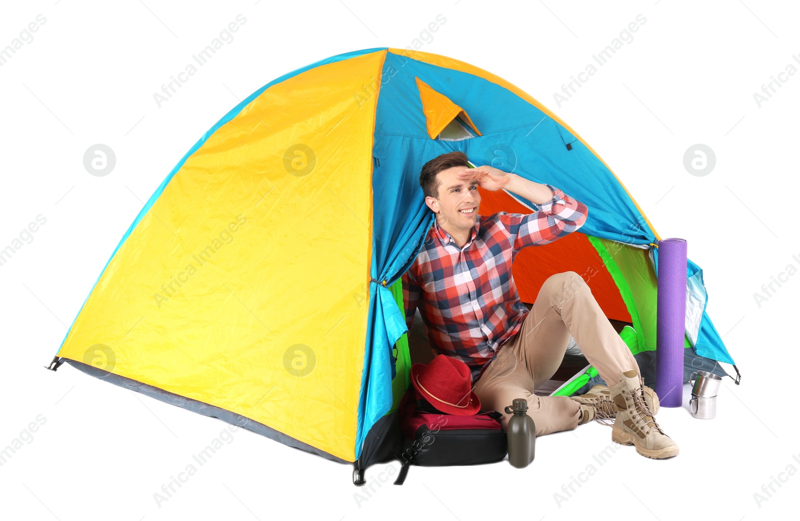 Photo of Young handsome man sitting in tourist tent on white background