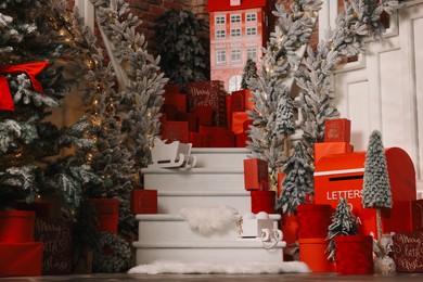 Photo of Christmas tree, gift boxes and festive decor indoors. Interior design