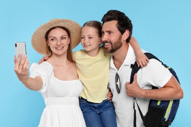 Photo of Happy family taking selfie on light blue background