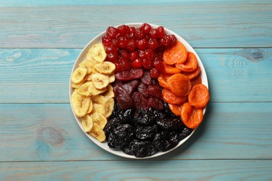 Delicious dried fruits on light blue wooden table, top view