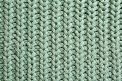 Photo of Beautiful pale green knitted fabric as background, top view