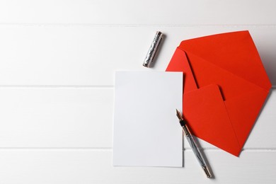 Photo of Blank sheet of paper, pen and letter envelope on white wooden table, top view. Space for text