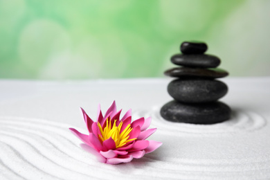 Photo of Zen garden. Beautiful lotus flower and stones on white sand