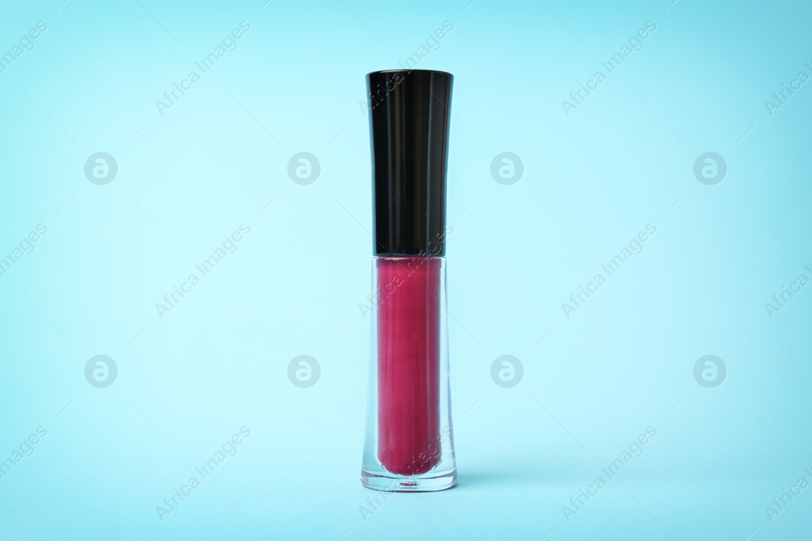 Photo of Beautiful lip gloss on color background