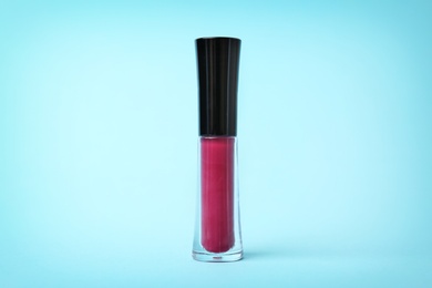 Photo of Beautiful lip gloss on color background