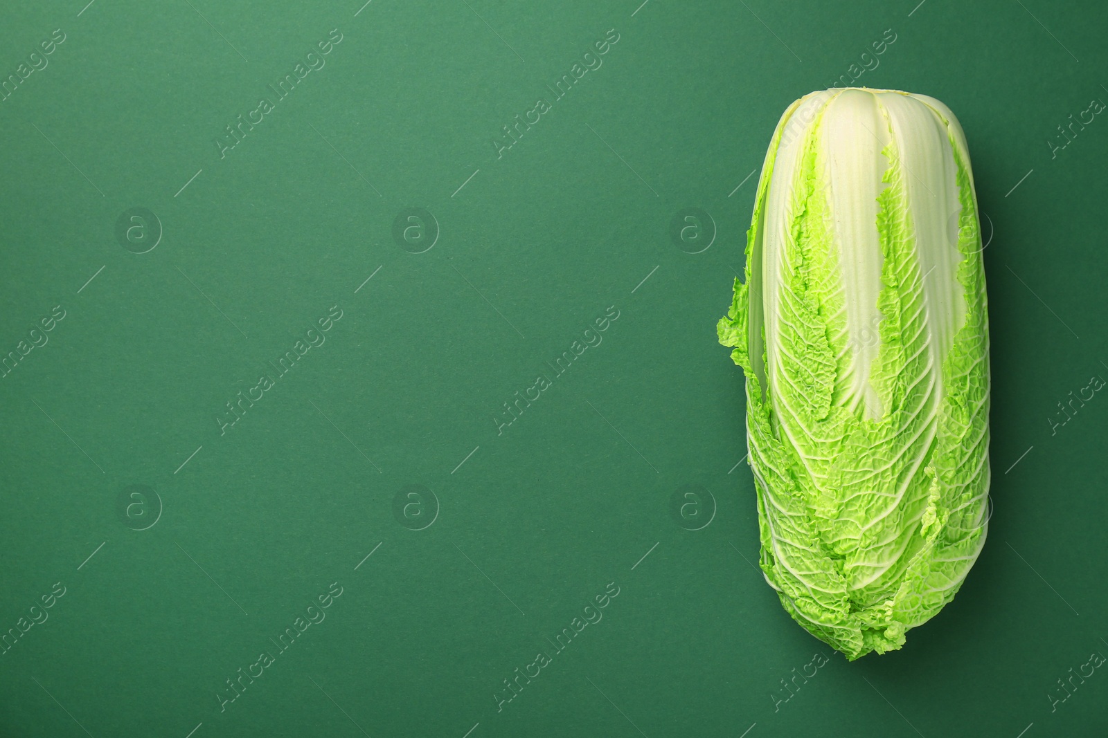 Photo of Fresh ripe Chinese cabbage on green background, top view. Space for text