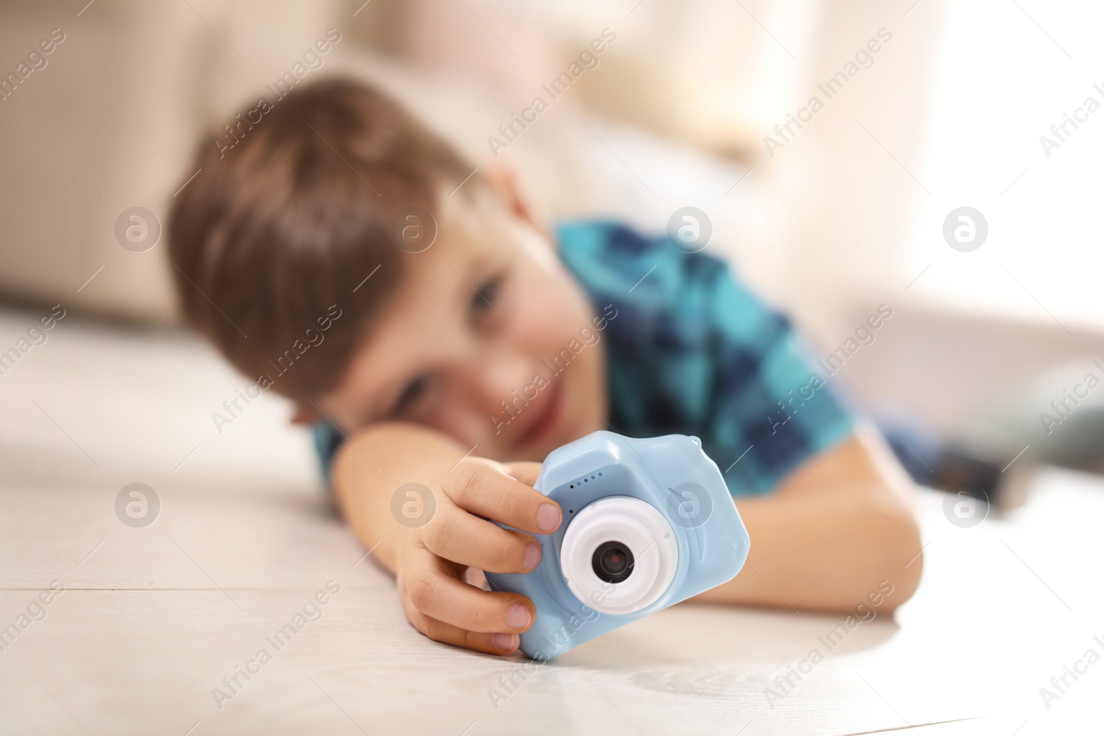 Photo of Little photographer indoors, focus on hand with toy camera