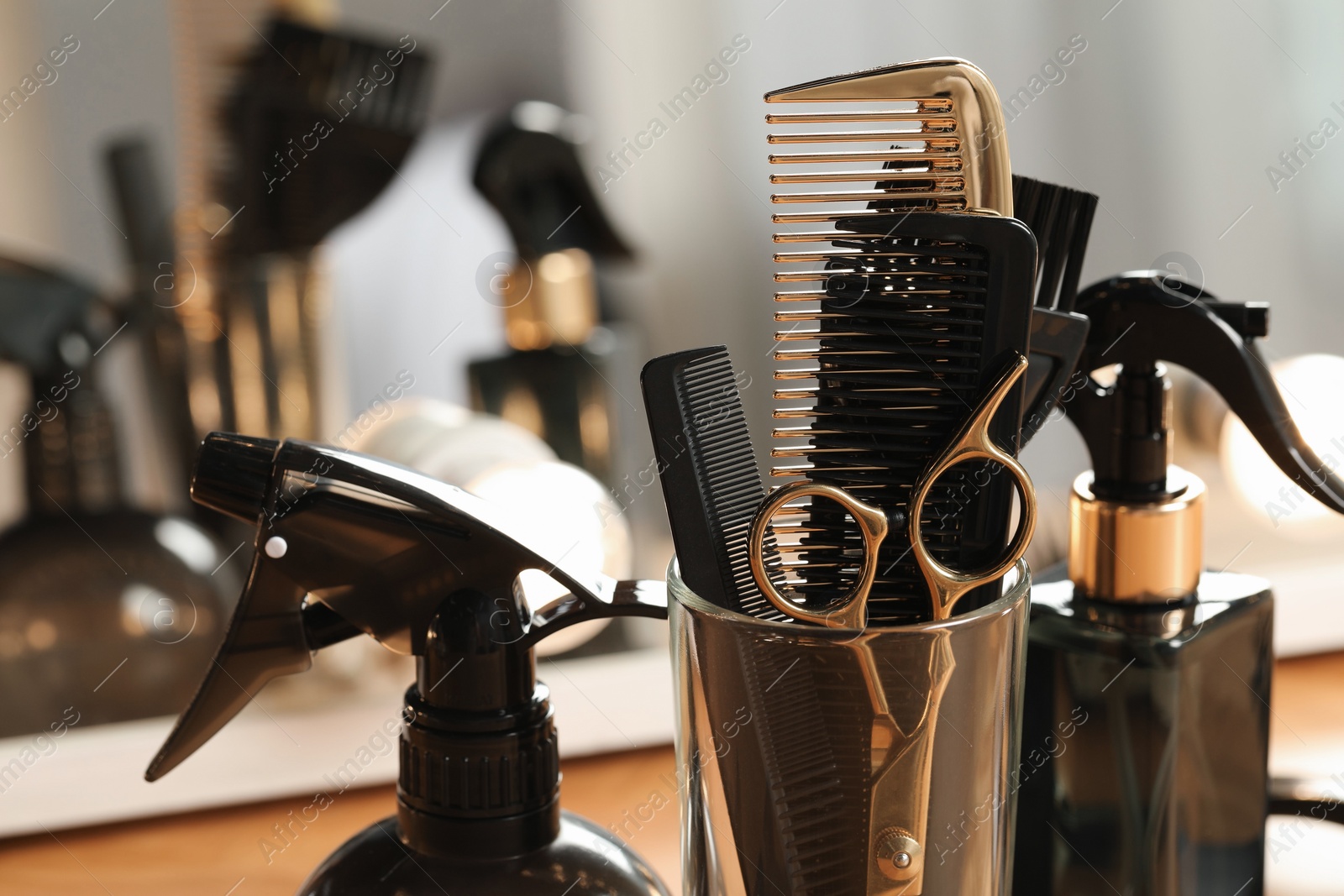 Photo of Set of hairdresser tools on table in salon, closeup