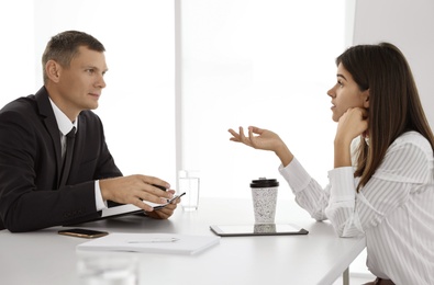 Office employees talking at table during meeting