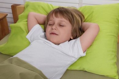 Photo of Little boy snoring while sleeping in bed indoors