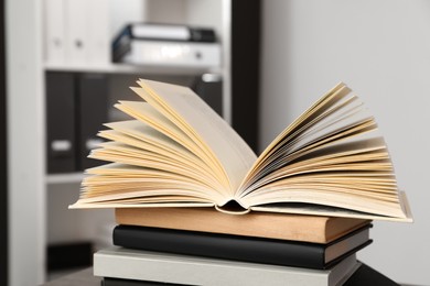 Photo of Stack of different hardcover books on wooden table indoors