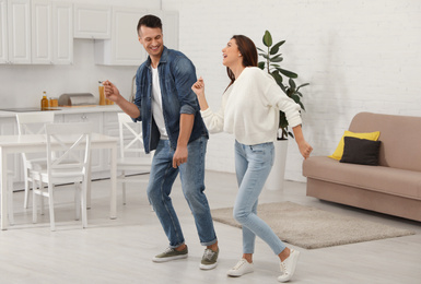 Photo of Happy couple dancing in kitchen at home